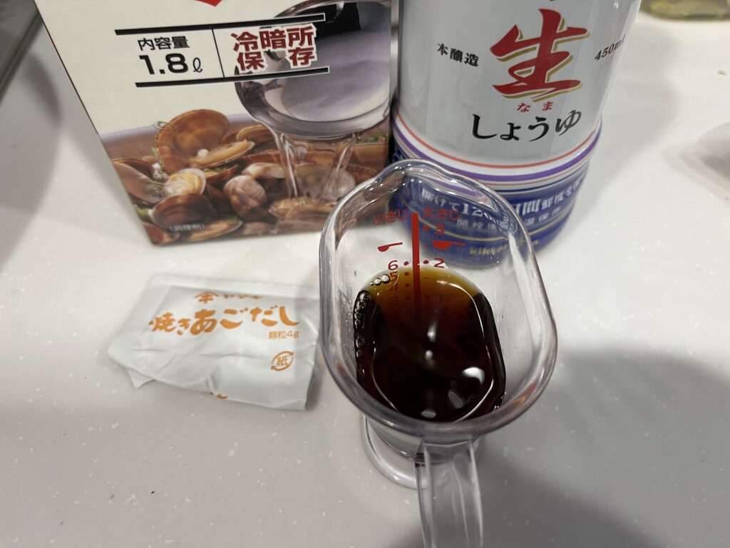 フライパンに入ったえごまの実と顆粒だし・酒・醤油などの調味料