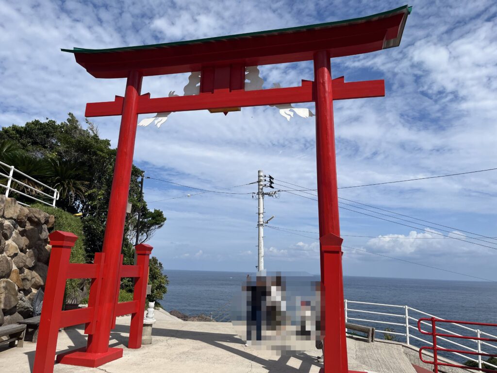 元乃隅神社の賽銭箱に向かって賽銭を投げる参拝者