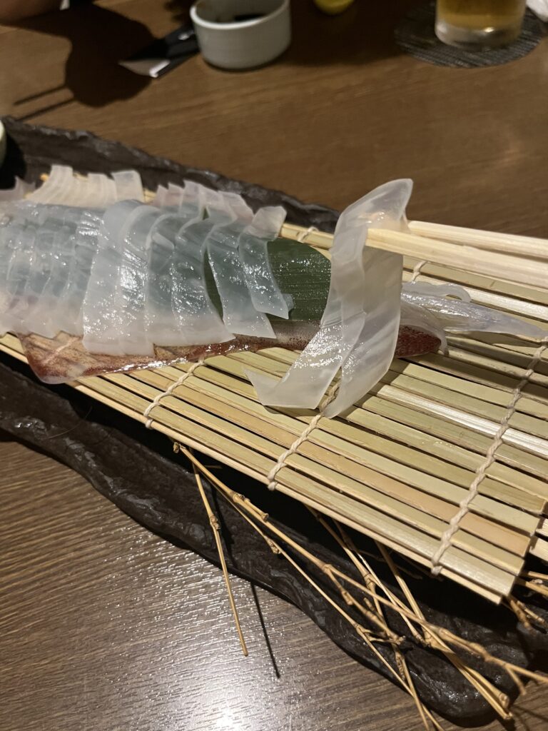 活イカ姿造り 刺身を箸で持ち上げた様子