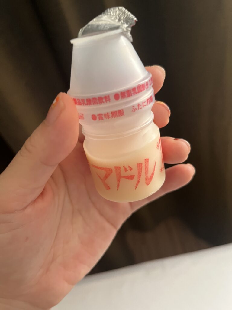 ドーミーインPREMIUM下関で朝風呂後に乳酸菌飲料を飲んでいる写真