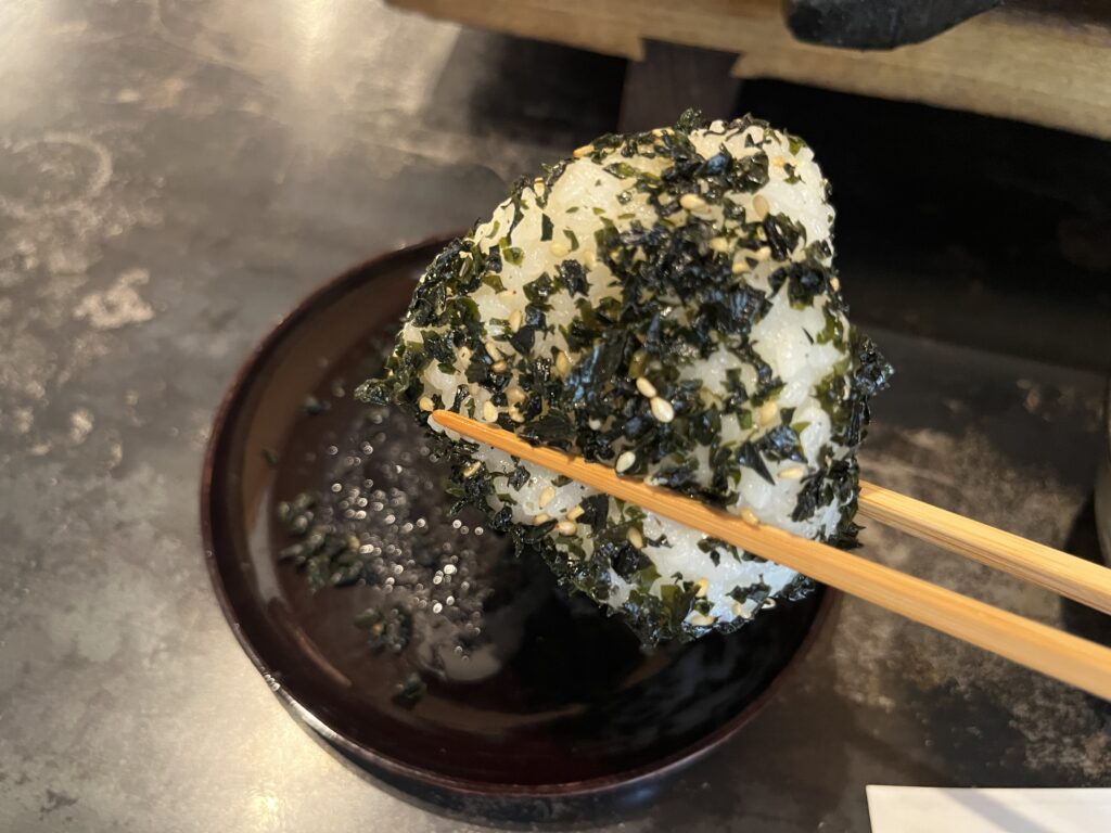 瓦そばセットのわかめむすびを箸で持ち上げた写真