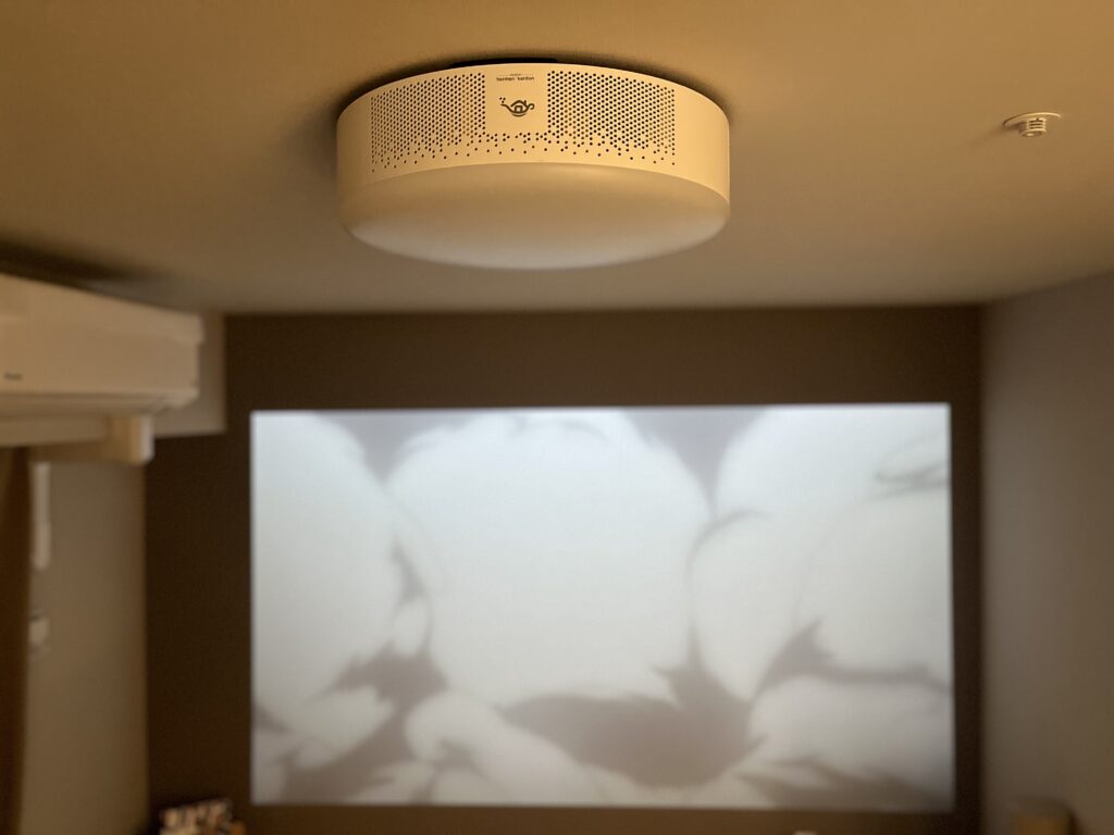 夜の部屋でAladdin X2 Plusが108インチのアニメ映像を投影している様子