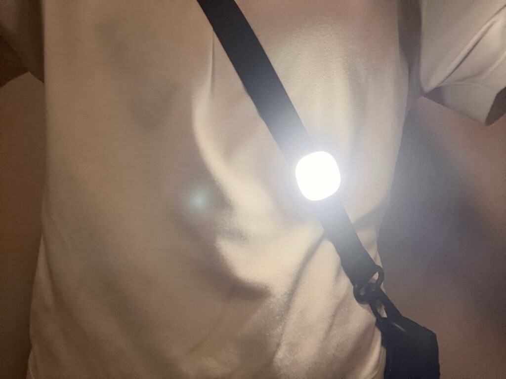 バッグの肩紐にクリップで留めて点灯している護衛さんライト
